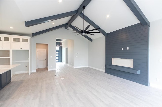 unfurnished living room with vaulted ceiling with beams, ceiling fan, a fireplace, and light wood-type flooring