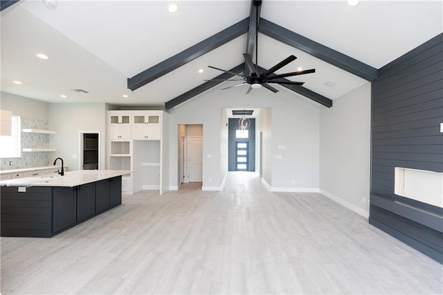 kitchen with lofted ceiling with beams, light hardwood / wood-style flooring, ceiling fan, and a healthy amount of sunlight