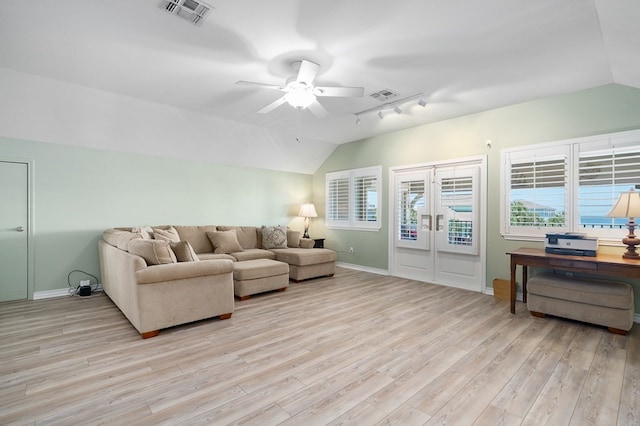 living room featuring lofted ceiling, track lighting, ceiling fan, and light wood-type flooring