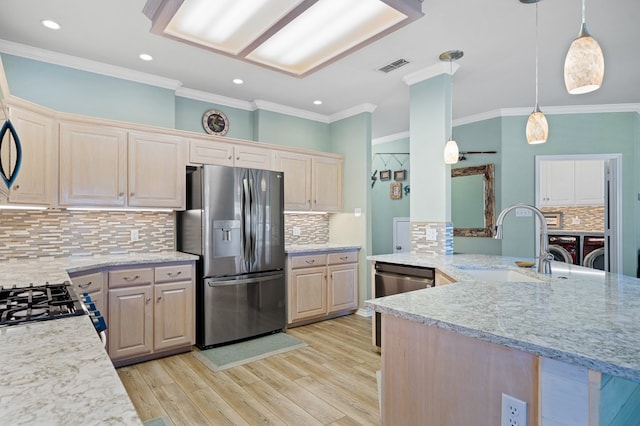 kitchen with decorative light fixtures, sink, kitchen peninsula, stainless steel appliances, and light stone countertops