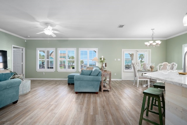 living room featuring ceiling fan with notable chandelier, ornamental molding, and light hardwood / wood-style floors