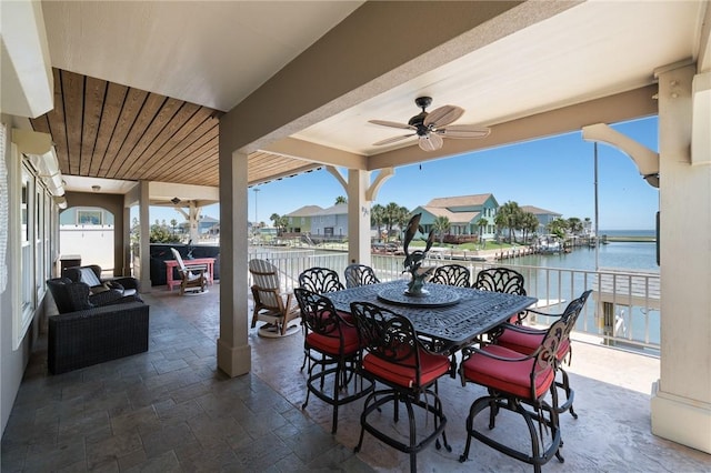 view of patio / terrace with outdoor dining area, ceiling fan, and a water view