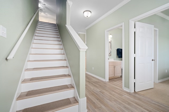 stairs with ornamental molding and hardwood / wood-style floors