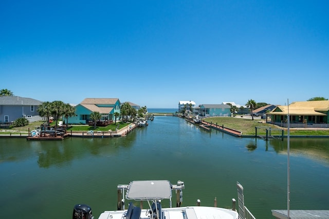 view of dock featuring a water view, a residential view, and boat lift