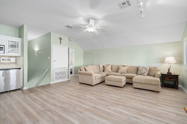 living room with ceiling fan, vaulted ceiling, visible vents, and light wood-type flooring