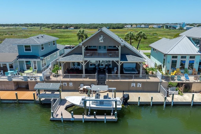 view of dock featuring boat lift, a patio, and a water view