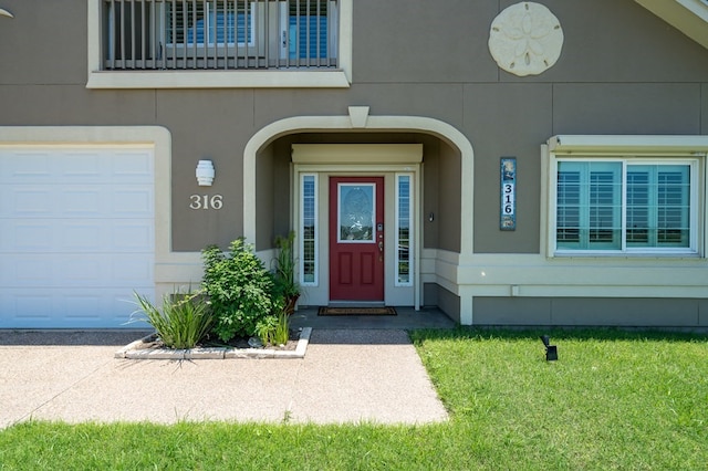 doorway to property with stucco siding and a garage