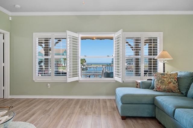 living area featuring baseboards, wood finished floors, a water view, and ornamental molding