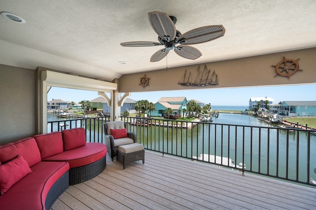 deck featuring an outdoor living space, a water view, and ceiling fan