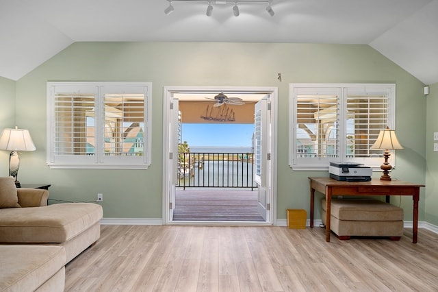 doorway featuring baseboards, lofted ceiling, and wood finished floors