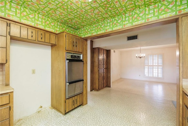 4826 Olympia Dr, Corpus Christi, TX 78413 - kitchen with a chandelier, stainless steel double oven, brown cabinetry, light countertops, and open floor plan
