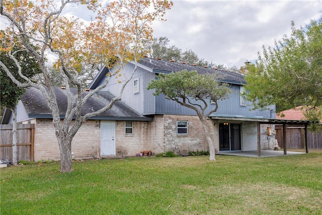 back of property with a patio area and a yard