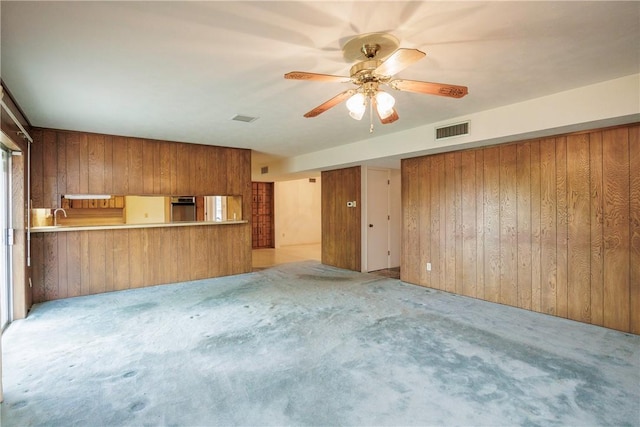 4826 Olympia Dr, Corpus Christi, TX 78413 - unfurnished living room with wooden walls, light carpet, and ceiling fan