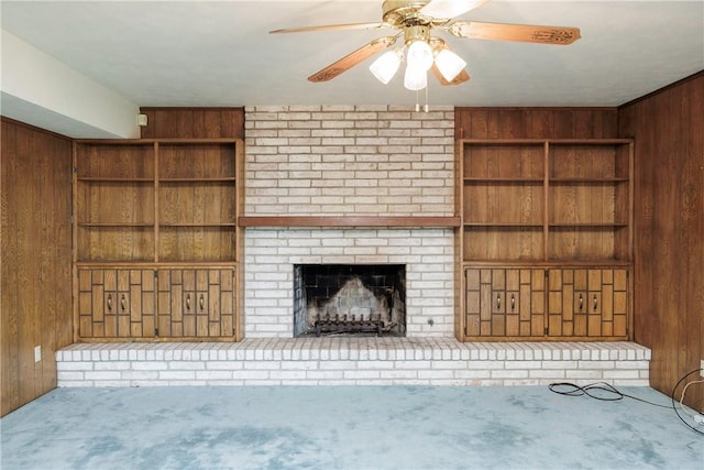 4826 Olympia Dr, Corpus Christi, TX 78413 - unfurnished living room featuring wood walls, carpet flooring, a fireplace, a ceiling fan, and built in shelves