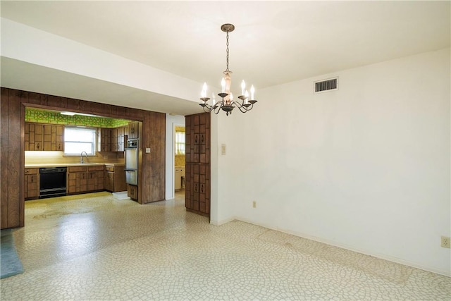 interior space featuring wood walls, sink, and a chandelier