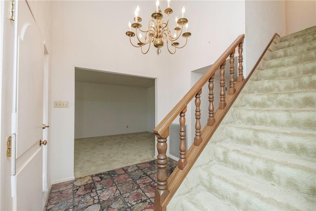 staircase featuring carpet flooring and an inviting chandelier