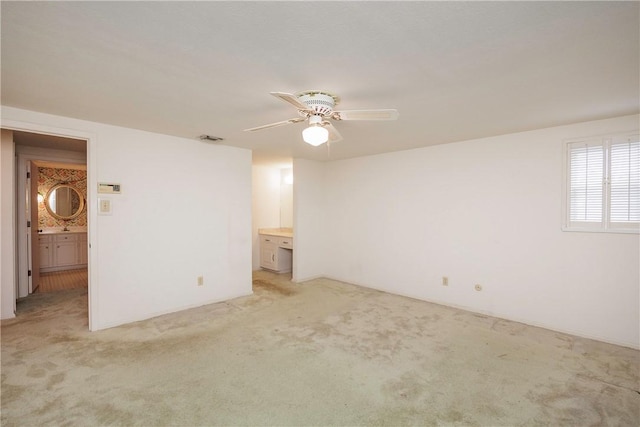 carpeted spare room featuring ceiling fan