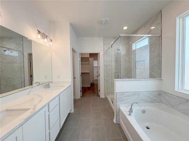 130 Broad Oak Dr, Rockport, TX 78382 - bathroom featuring double vanity, a bath, a stall shower, a spacious closet, and recessed lighting