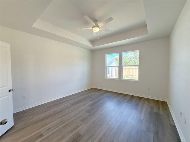 130 Broad Oak Dr, Rockport, TX 78382 - spare room featuring a tray ceiling, a ceiling fan, and dark wood-type flooring