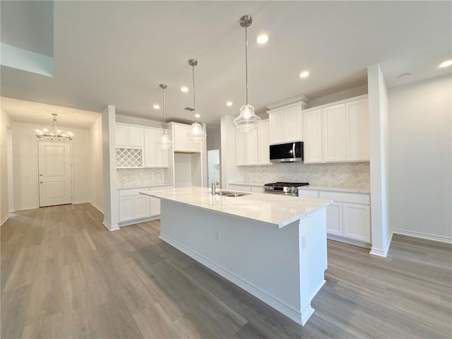 130 Broad Oak Dr, Rockport, TX 78382 - kitchen with appliances with stainless steel finishes, decorative backsplash, light wood-style floors, recessed lighting, and a spacious island