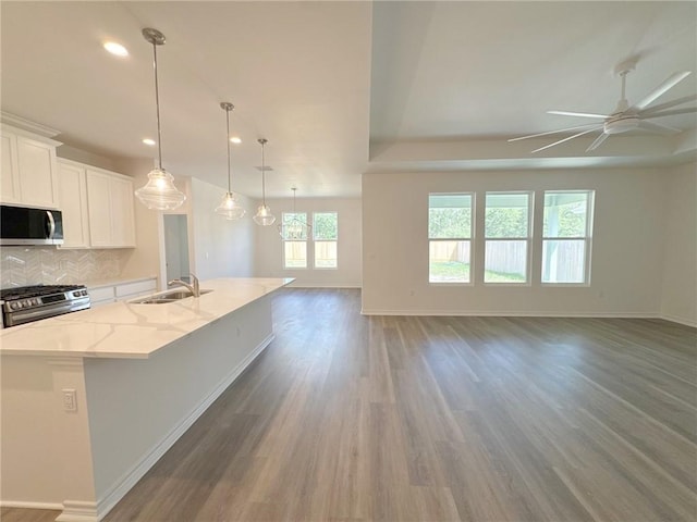 130 Broad Oak Dr, Rockport, TX 78382 - kitchen with appliances with stainless steel finishes, open floor plan, ceiling fan, wood finished floors, and an island with sink