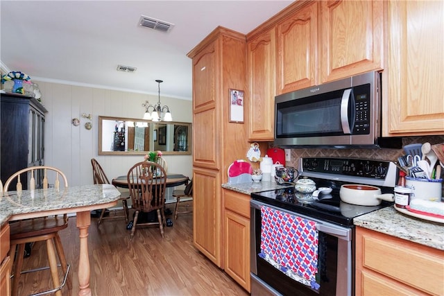 10639 Emmord Loop, Corpus Christi, TX 78410 - kitchen featuring appliances with stainless steel finishes, backsplash, a chandelier, light wood-style floors, and ornamental molding