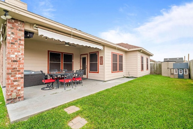 rear view of house featuring an outdoor structure, fence, a patio area, a lawn, and a storage shed