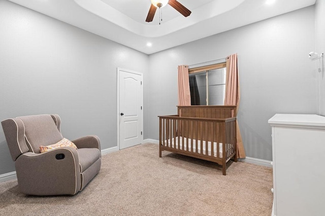bedroom with a nursery area, ceiling fan, light colored carpet, recessed lighting, and baseboards