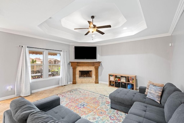 living room featuring ceiling fan, ornamental molding, and baseboards