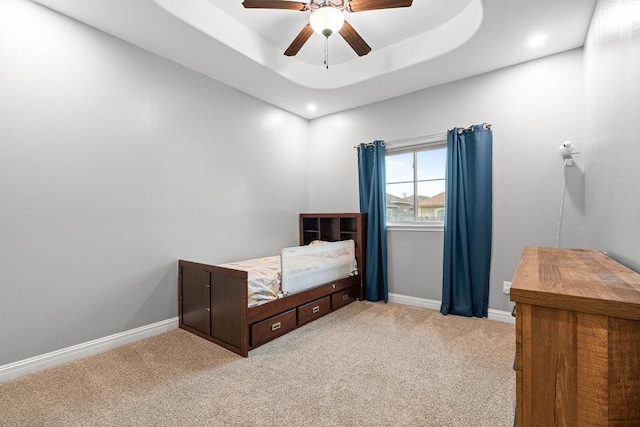 carpeted bedroom featuring baseboards, ceiling fan, recessed lighting, and a raised ceiling