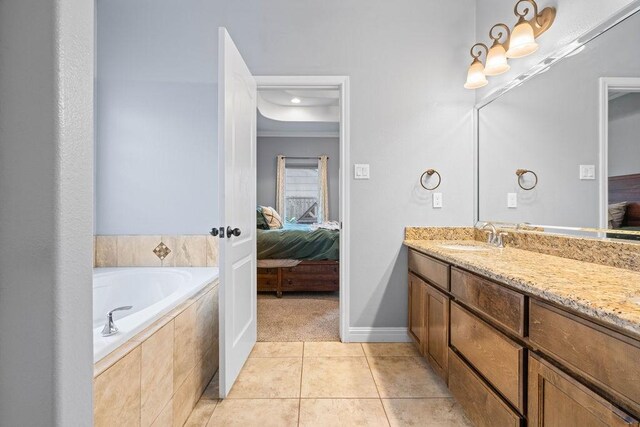 ensuite bathroom with vanity, tile patterned floors, baseboards, ensuite bathroom, and a bath