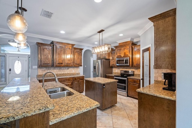 kitchen with visible vents, a center island, arched walkways, a sink, and stainless steel appliances