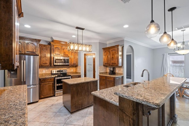 6821 Sir Moses Pl, Corpus Christi, TX 78414 - kitchen featuring stainless steel appliances, a kitchen island with sink, a sink, arched walkways, and backsplash