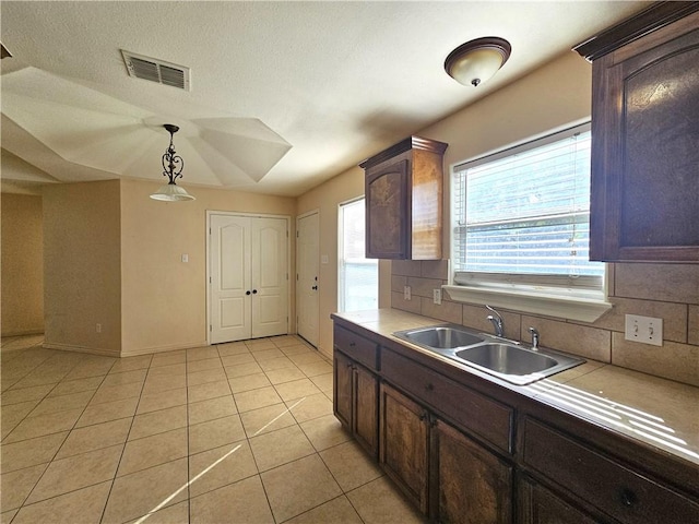 4318 Ivy, Corpus Christi, TX 78415 - kitchen featuring a sink, decorative backsplash, light tile patterned flooring, pendant lighting, and baseboards