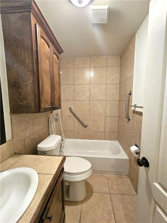 4318 Ivy, Corpus Christi, TX 78415 - full bath with tile patterned floors, vanity, toilet,  shower combination, and decorative backsplash