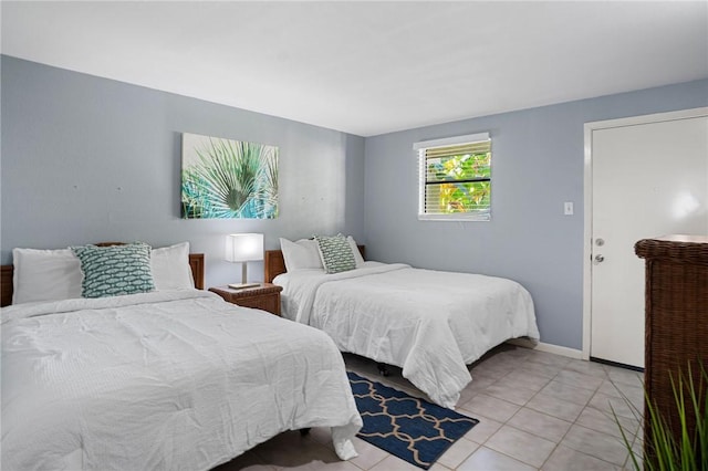 bedroom featuring light tile patterned floors and baseboards