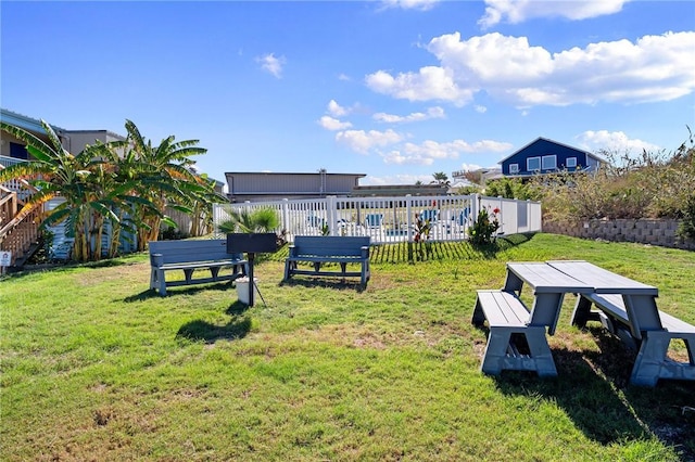 view of home's community with a yard and fence