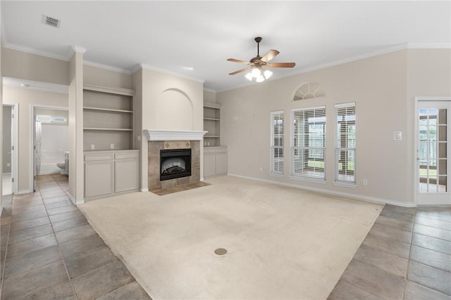 unfurnished living room with a fireplace, ornamental molding, and built in shelves