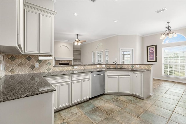 kitchen with kitchen peninsula, stainless steel dishwasher, crown molding, and tasteful backsplash