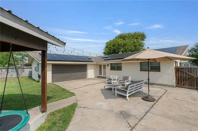 116 Daniel Moore St, Portland, TX 78374 - rear view of house featuring roof mounted solar panels, brick siding, french doors, a patio area, and an attached garage