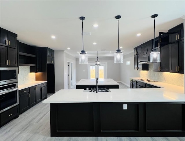7722 Nadia Dr, Corpus Christi, TX 78414 - kitchen featuring stainless steel appliances, dark cabinetry, a sink, tasteful backsplash, and light countertops