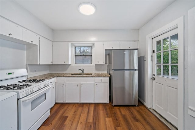 kitchen with freestanding refrigerator, white range with gas stovetop, a sink, and dark wood finished floors
