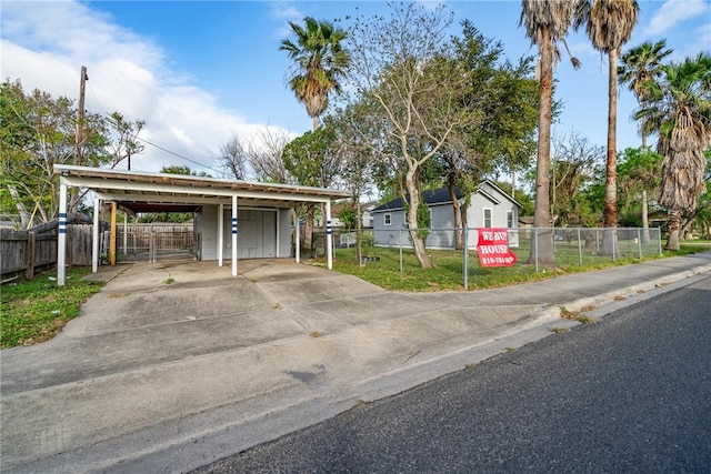 exterior space with a gate, fence, driveway, and a front yard