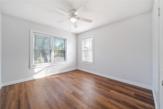 empty room with baseboards, dark wood-type flooring, and ceiling fan