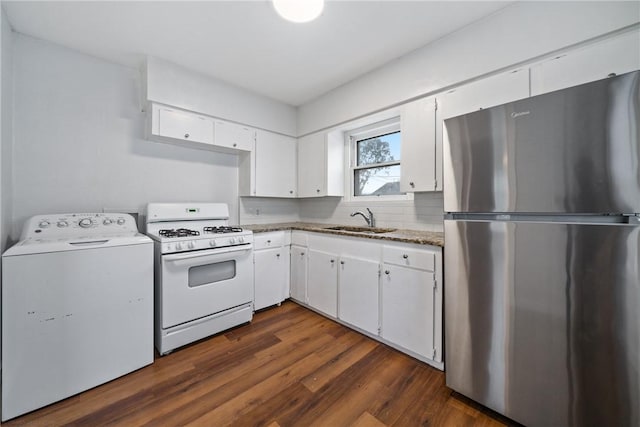 kitchen featuring white gas range, a sink, washer / dryer, white cabinets, and freestanding refrigerator