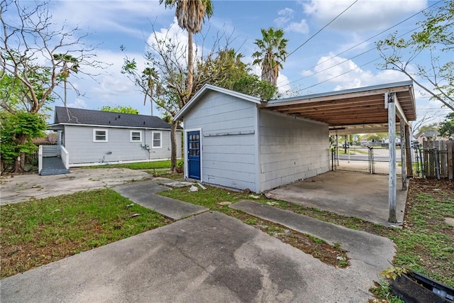 view of outbuilding with an outdoor structure, a carport, and fence