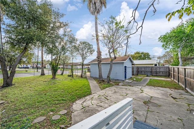 view of yard featuring an outbuilding, a patio, and a fenced backyard