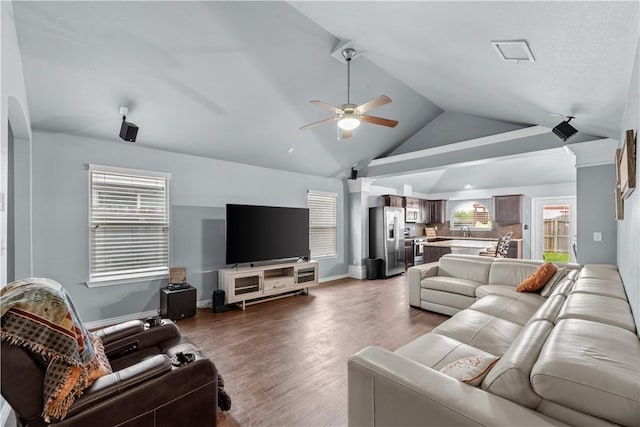 living room with ceiling fan, vaulted ceiling, and light wood-type flooring