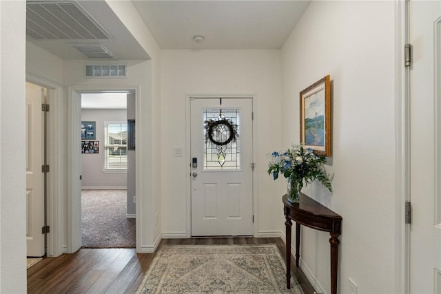 entryway with wood finished floors, visible vents, and baseboards