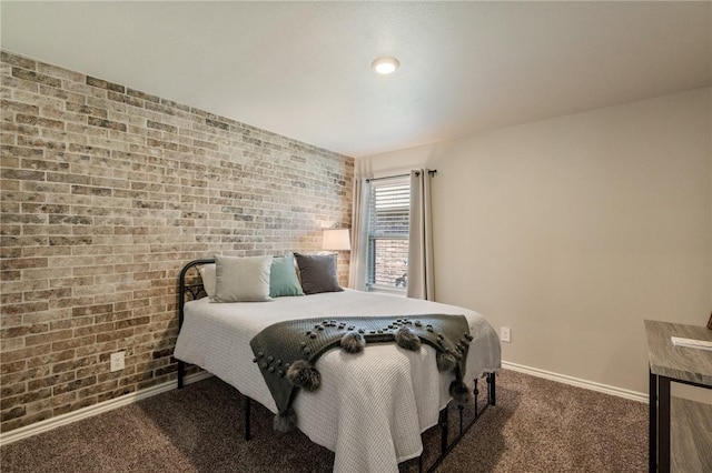 carpeted bedroom with brick wall and baseboards